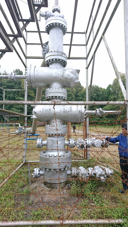 Portrait photograph of wellhead piping, valves and steel supports; brightness and clarity adjusted